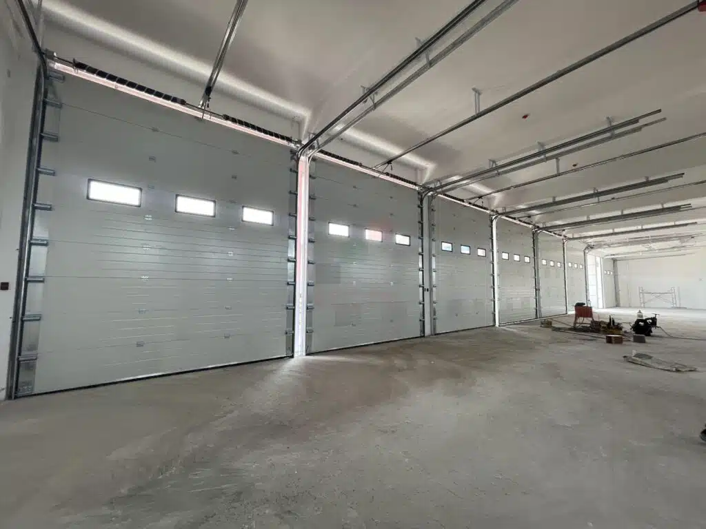 Maxwell Shutters technician in hard hat installing garage door in Dubai