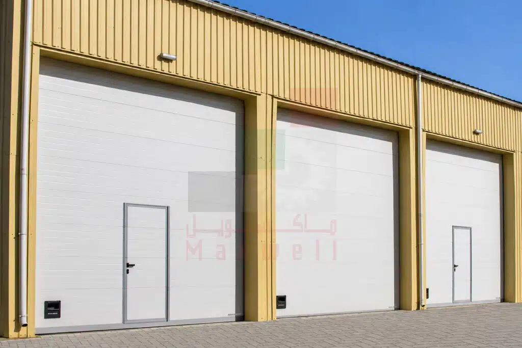 White industrial overhead door inside a warehouse with exposed wood ceiling
