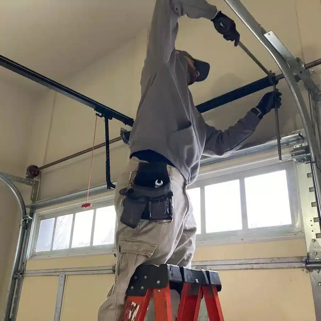 Man adjusting garage door track and shutters