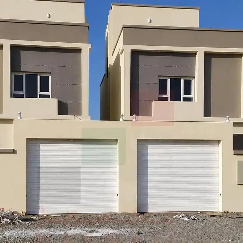 Modern home with two white rolling shutters on garage doors.